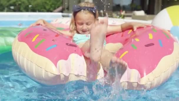 Sluiten Schattig Meisje Drijvend Zwembad Opblaasbare Donut Spetterend Water Vrolijk — Stockvideo