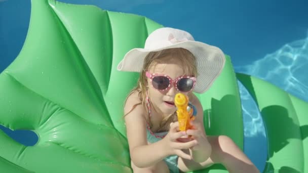 Close Little Girl Sitting Floatie Water Gun Pointing Camera Cheerful — Stock Video