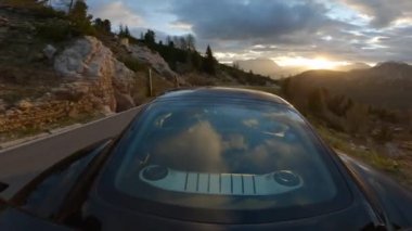 GAU PASS, DOLOMITES, ITALY, MAYIS 2022: altın saat dağ yolunda yokuş aşağı sürerken şaşırtıcı alp manzarası. İtalyan Alpleri 'nin ortasındaki dolambaçlı dağ geçidinden manzaralı bir yolculuk..