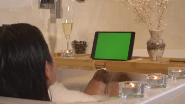 在泡泡浴和看网上视频时 放松了的年轻女士 漂亮的女人在家里的浴室里放松一下 自己也有时间 减轻压力和照顾身体的家庭健康 — 图库视频影像