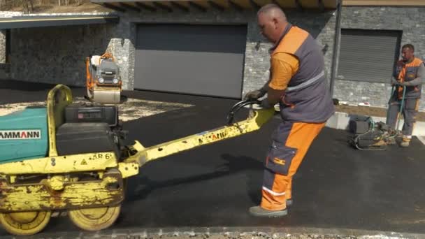 2022年4月 Ljubljana Slovenia 两名建筑工人用沥青路面机械平整路面 晨光下操作沥青压路机和振动压路机的建筑工人 — 图库视频影像