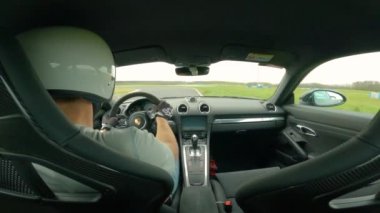 EYLÜL 2022, PANNONIARing, HUNGARY: yarış pistinde yarış arabası ile hızlı tur süren genç bir erkek görüntüsü. Asfalt pistinde hızlı giden bir sürücü ile hızlı bir spor araba..