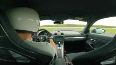 Eylül 2022, PANNONIARing, HUNGARY: direksiyon başında genç bir adam yarış pistinde arabayla hızlı tur atıyor. Asfalt pistinde hızlı giden bir sürücü ile hızlı bir spor araba..