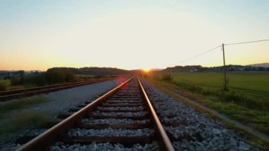 Sonbahar sabahı ışıldayan altın ışıklı demiryolu raylarının üzerine çıkmak. Kırsal demiryolu muhteşem tepe manzarasını geçiyor. Tren istasyonu yakınlarındaki tren yolu ve kavşağı genel görünümü.