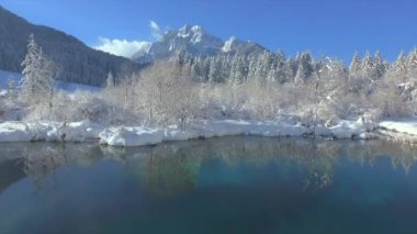 Zelenci 'deki su yansımasından karlı Ponce Dağları' na doğru uçuyor. Zelenci 'deki muhteşem kar manzarası dağ manzarası ve kristal kaynak suyu. Alplerde muhteşem bir kış anı..