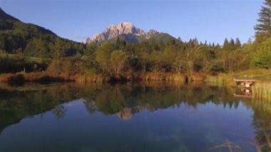 Zelenci Springs 'in sularındaki Ponce Dağları' nın nefes kesici yansıması. Sonbahar mevsiminde göl suyundan dağlara doğru uçar. Altın sonbahar güneşinde göz kamaştırıcı dağ manzarası.