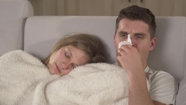 Close Young Man Sneezing Waking His Wife While Both Rest — Vídeo de Stock