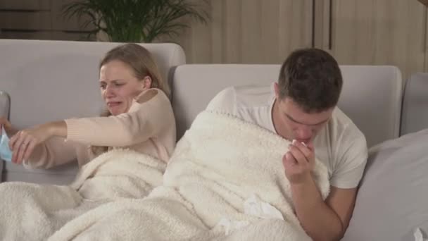 Close Young Man Sneezes Young Woman Puts Protective Face Mask — Videoclip de stoc
