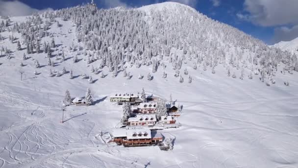 雪地高山滑雪场中央的山舍景致宜人 酒店大楼四周环绕着美丽的高山自然 覆盖着刚刚落下的雪 阿尔卑斯山冬季仙境 — 图库视频影像