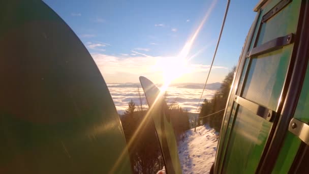 閉じる スキーリゾートから霧の谷までのケーブルカーで絵のように美しい乗り物 高山スキー場での雪の上の冬のスポーツ活動の一日の後の山からの降下中の素晴らしい景色 — ストック動画