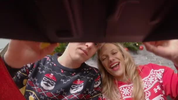 Close Ein Glückliches Paar Weihnachtspullovern Öffnet Eine Schachtel Mit Dekorationen — Stockvideo