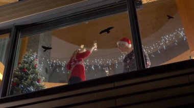 Noel arifesini dışarıda kar yağarken kutlayan neşeli bir çift. Dans eden kadın ve erkek Noel tatili için parti veriyorlar. Neşeli kış akşamında birlikte gülen bir çift..