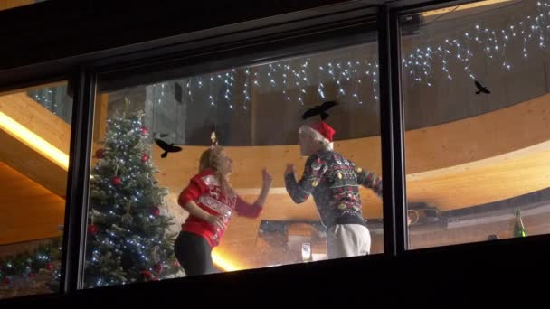 低角度概述 在圣诞节前夕 当外面下着雪时 舞伴们在尽情享受着 快乐的女人和男人在圣诞节庆祝 在喜庆的冬夜 一对欢欢欢喜喜的情侣在一起 — 图库视频影像
