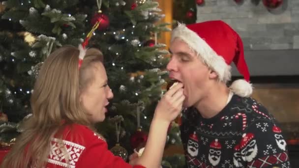 Close Young Couple Love Eating Christmas Desserts Next Decorated Tree — Vídeo de stock