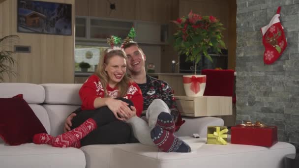 Χαριτωμένο Ζευγάρι Στολή Χριστουγέννων Γελώντας Ενώ Έβλεπε Χριστουγεννιάτικη Κωμωδία Χαρούμενος — Αρχείο Βίντεο