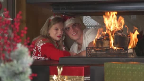 Loving Christmas Couple Leaning Each Other Looking Burning Fireplace Cheerful — Vídeos de Stock