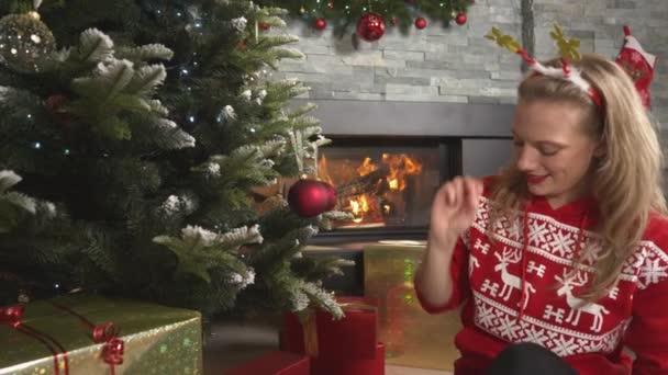 Beautiful Cheerful Woman Decorating Christmas Tree Red Baubles Fireplace Smiling — Wideo stockowe