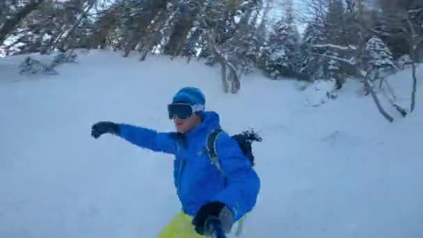 Portrait パウダースノーになると山の森を滑り降りる男 雪山の中で新鮮なパウダースノーを楽しむスノーボーダー アドレナリンの冬の休日のための屋外活動 — ストック動画