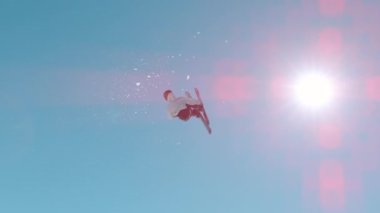 VOGEL, BOHINJ, JULIAN ALPS, SLOVENIA, MARCH 2022: SLOW MOTION: Male skier jumping big air kicker at snow park in snowy ski area. Extreme skier double rotating through the air and performing grab trick
