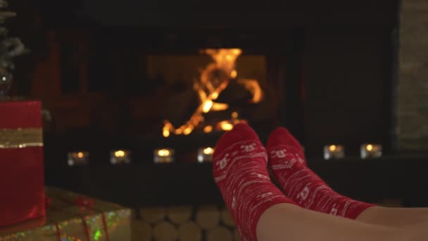 Close Жіночі Ноги Червоних Різдвяних Шкарпетках Прогріваються Перед Каміном Жінка — стокове відео