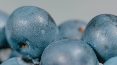 MACRO, DOF: Close up shot of a handful of juicy organic blueberry shining under a bright light. High detailed shot of a basket full of plump homegrown blueberries. Delicious natural dessert ingredient