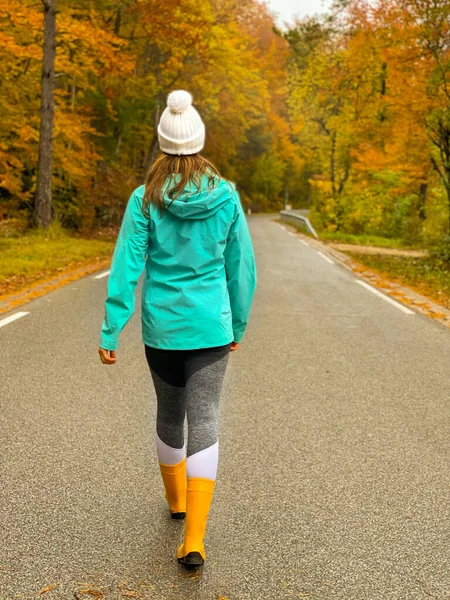 Woman Strolls Scenic Autumn Colored Forest Road Young Female Traveler — Φωτογραφία Αρχείου