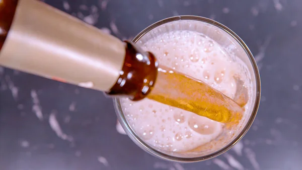 アップ トップダウン ドーフ 冷たいIpaビールは 茶色のヴィンテージボトルからガラスに注ぎ出されます レトロなボトルから淡いエールが注がれます 生ビールをマグカップに入れる — ストック写真