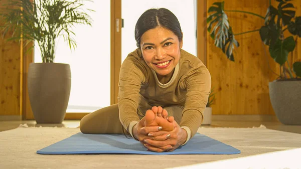 Happy Young Asian Woman Seated Head Knee Yoga Pose Blue — стоковое фото