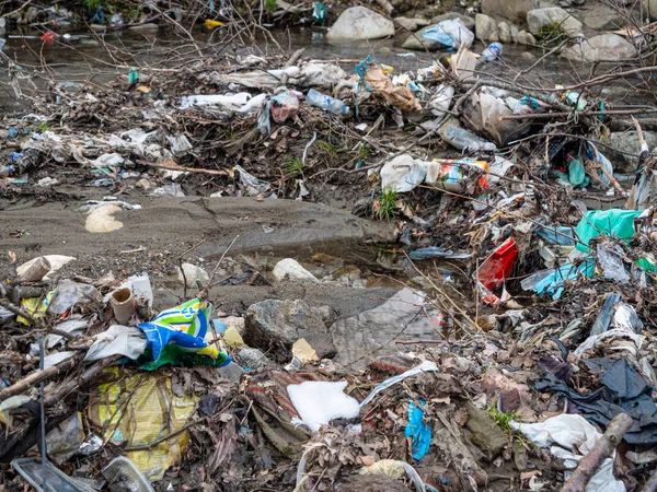 Tirana Albania 2022年3月 川のすぐ近くでプラスチックごみと土石流の混合物 環境悪化につながる不適切なプラスチック廃棄物の処分と川の悲しい光景 — ストック写真