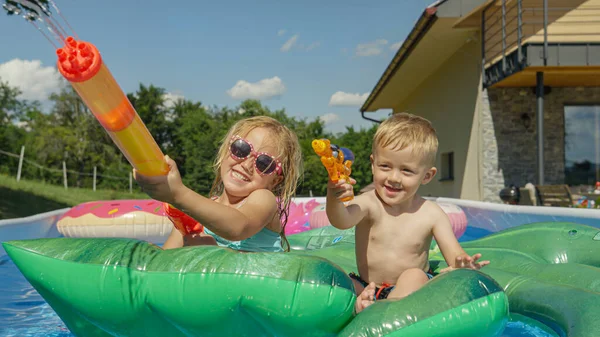 Close Cheerful Little Children Floating Pool Spraying Water Guns Water — Stok fotoğraf