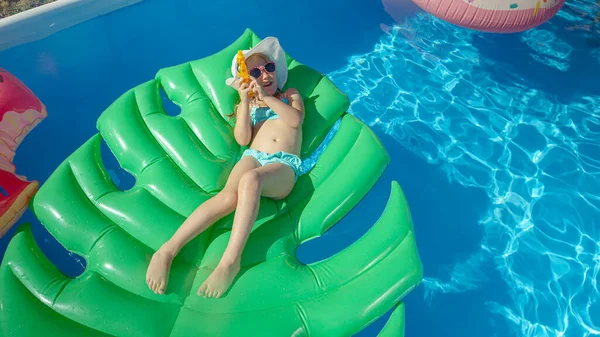 Top Adorable Playful Little Girl Lying Floatie Holding Water Gun — Stok fotoğraf