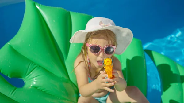 Top Little Girl Sitting Floatie Water Gun Pointing Camera Cheerful — Stok fotoğraf
