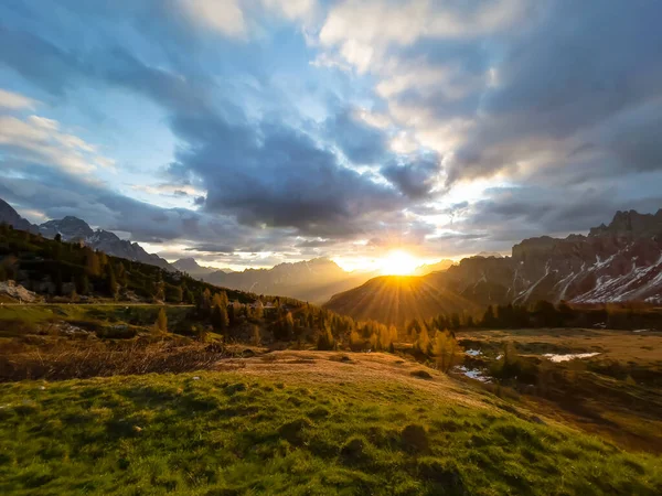 日の出の光に輝くドロマイトの山の風景の絵のような景色 山頂上のカラフルな雲と太陽の最初の線を通して目を通す 一日の始めに息を飲む瞬間 — ストック写真