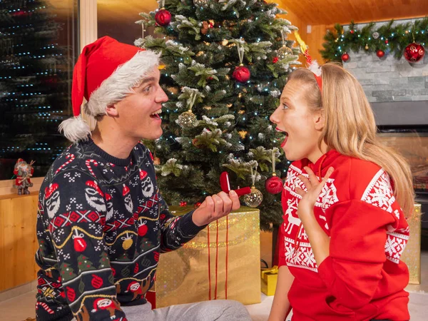 Loving Couple Romantic Engagement Christmas Tree Young Man Surprises His — Φωτογραφία Αρχείου