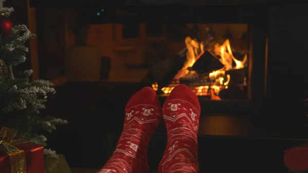 暖炉でリラックスし クリスマスの靴下で足を暖める女性 クリスマスの夜に美しく装飾された自宅のリビングルームの快適さを楽しんで休んでいる女性の人 — ストック写真