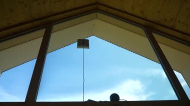 LOW ANGLE VIEW: Robotic window cleaner washing glass on hard-to-reach windows. Handy modern electronic device for futuristic housekeeping. Household helper for maintaining the cleanliness of windows.