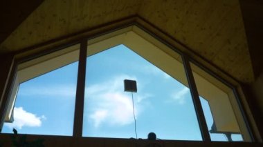 LOW ANGLE VIEW: Automatic window cleaner robot washing glass on high windows. Handy modern electronic device for futuristic housekeeping. Household helper for maintaining the cleanliness of windows.