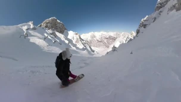 雪山ゲレンデでは若い女性が新雪をスプレーしながらターンを繰り返せました 新雪を感じながらパウダースノーを満喫する女性スノーボーダー — ストック動画