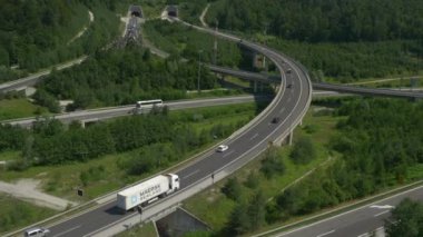 Karayolu trafiğinin üzerinde uçuyorlar. Otoyol kavşağında giden arabalar ve yük kamyonları.. 