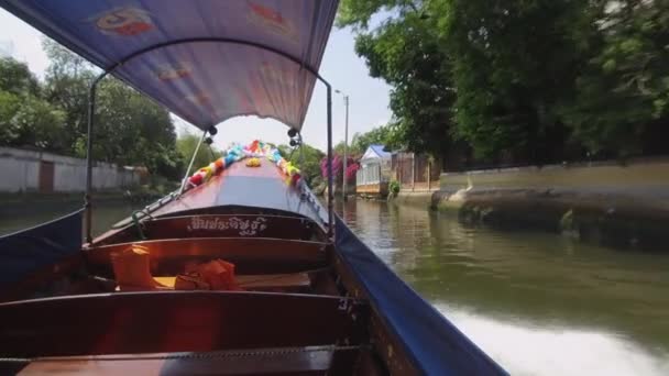 Low Angle 花で飾られた川沿いの家を過ぎるロングテールボートの速度 — ストック動画