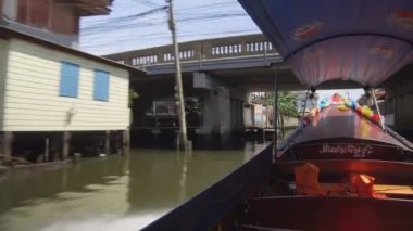 LOW ANGLE: Wooden water taxi speeding on polluted river canal under small bridge