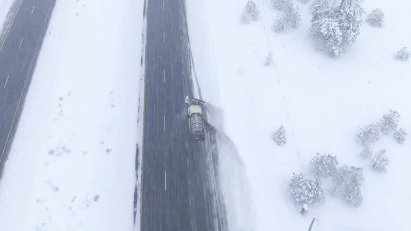 ドローン 雪のように激しい吹雪の中を飛ぶことは 米国ワシントンの氷の道をクリアします トラックプラス新鮮な雪アスファルト高速道路の側に集まった 氷の道を掃除するトラック — ストック写真
