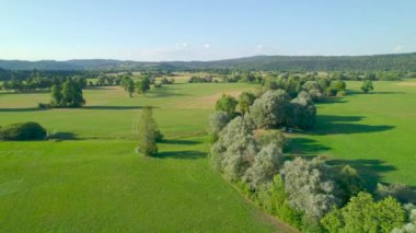 Bereketli yeşilliklerle çevrili, başıboş nehir, tarlaların arasından esiyor. Yavaş akan bir nehir ve canlı yeşil çayırlar ile dolu güzel bir yaz öğleden sonrası güneşi.