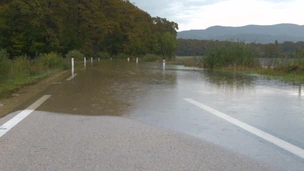 河水漫过河岸 淹没了农村的部分沥青路面 铺面的公路被淹没在水下 不能通行 秋雨充沛 洪水泛滥 — 图库视频影像