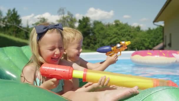 和可爱的小孩在游泳池里泼洒水枪的快乐时刻 炎炎夏日 花园里有许多有趣的水活动 在水上游玩的时候 开心的孩子们笑得很开心 — 图库视频影像