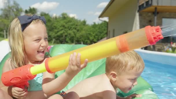 Close Чарівна Дівчинка Хлопчик Розбризкує Водяними Гарматами Плаваючи Басейні Усміхнені — стокове відео