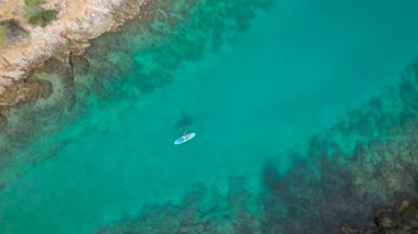 HVAR ISLAND, CROATIA, 05.05.2023: Bayan sadık tüylü arkadaşıyla birlikte Hırvatistan 'ın pitoresk adasında yaz tatillerinde kürek çekerken ayağa kalkın.