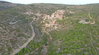 Dağlık kayalık bir araziye inşa edilmiş otantik evleri olan küçük bir yerleşim yeri. Adriyatik adası Hvar 'daki eski bir köye giden dolambaçlı bir yol. Yaz tatilinde manzaralı kırları keşfetmek.