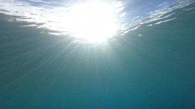 Güneş ışınları kristal berrak mavi Adriyatik Denizi 'nin yüzeyinin altına yayılıyor. Şeffaf deniz suyunda parlayan güzel güneş ışınları. Saf mavilikte parıldayan güneş ışınlarıyla inanılmaz bir manzara.