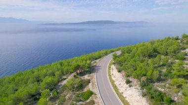 Adriyatik Denizi 'nin pitoresk kıyıları boyunca uzanan panoramik otoyol. Sarmal asfalt yolu Akdeniz manzarasına oyulmuş çarpıcı derin mavi deniz ve dağınık adalar..